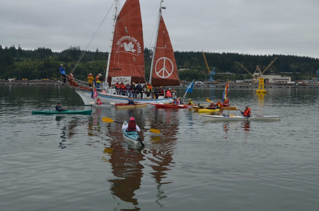 The Golden Rule and kayaks with OHIO Class (Trident) submarine visible in background at Naval Base Kitsap-Bangor Delta Pier on August 9th