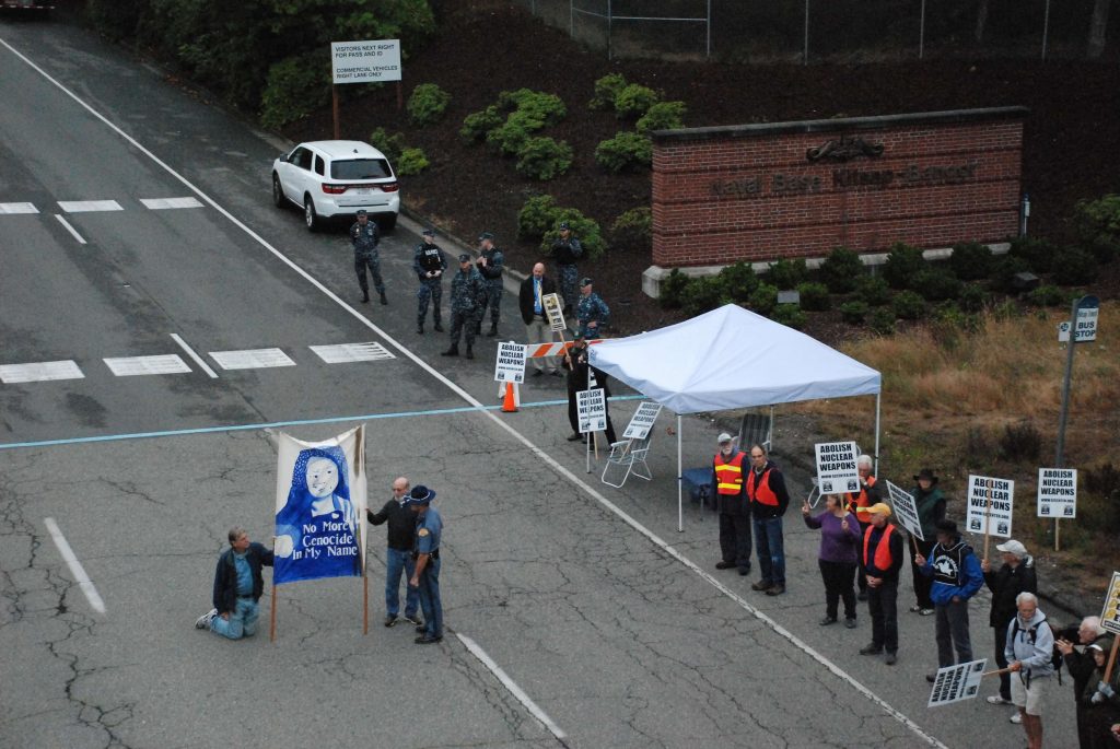 Philip Davis, Bremerton WA and George Rodkey blocking the roadway at the Bangor Main Gate on August 8th